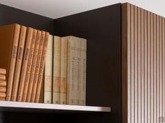 The shelf of the Plan 38 wall system, fixed to the lacquered back panel, is available in finishes to match the base and can be used as a bookshelf