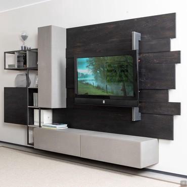 Wall system with bookshelf FreeHand 02 equipped with wall units, bookshelf, base and wall panels with orientable TV panel. Available in dark and light grey oak.