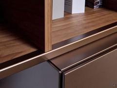 Freehand open element against a flap wall unit, both with bronze metal finish details