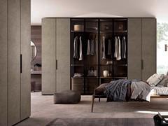 L'armoire de luxe avec portes battantes revêtues de simili-cuir ou de tissu Moon Lounge peut également être combinée avec des modules du dressing à porte vitrée Artemis Lounge grâce à sa modularité