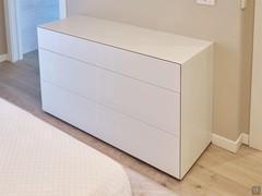 Commode à 3 tiroirs largeur cm 120, hauteur cm 74 configurée avec des pieds bas. Finition laquée blanc mat