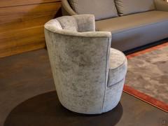 Vue latérale du fauteuil Petra dans le modèle XL avec socle haut en velours Vegas