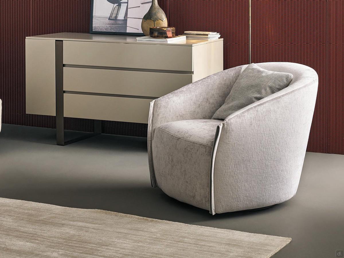 Fauteuil Bodo avec base pivotante de Bonaldo, ici proposé revêtu de tissu avec des inserts en cuir Capri au niveau des accoudoirs.