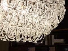 Détail des pendentifs en cristal en forme de crochet, littéralement suspendus au squelette métallique de la lampe suspendue Giogali