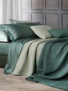 Ensemble de literie composé de draps en satin fin dans les coloris Mugo Pine et Pearl, associés au couvre-lit en coton léger en nid d'abeille disponible dans différents coloris.