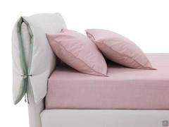 Détail du coussin de tête de lit réalisé dans le même tissu que le lit, avec une face intérieure contrastée permettant de le tourner à volonté