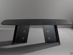 Esthétique élégante de la table Botón, riche en reflets et en jeux de lumière grâce au verre granité