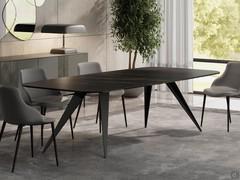 Pegaso Table avec pieds pointus en métal peint en noir et plateau tonneau en verre céramique noir mat : une combinaison très élégante et raffinée.