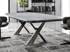 Table Mad Max dans la version avec plateau en céramique Keramik (finition non disponible) soutenue par un important dessous de plateau aux angles biseautés en laque gris brossé mat assorti à la base en acier.