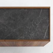 Pregiata finitura del top in pietra ceramica opaca grigio ardesia in contrasto alla credenza Outline di Bonaldo