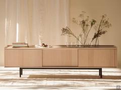 Credenza Katen a tre ante scorrevoli in frassino naturale, qui nella versione con basamento basso da 22 cm che le dà un'altezza complessiva di 63 cm