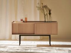 Credenza con ante scorrevoli in legno Katen, con basamento alto in metallo laccato opaco nero.