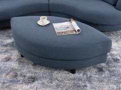 Particolare del pouf ovale che si inserisce nella curvatura del divano per formare un'isola relax