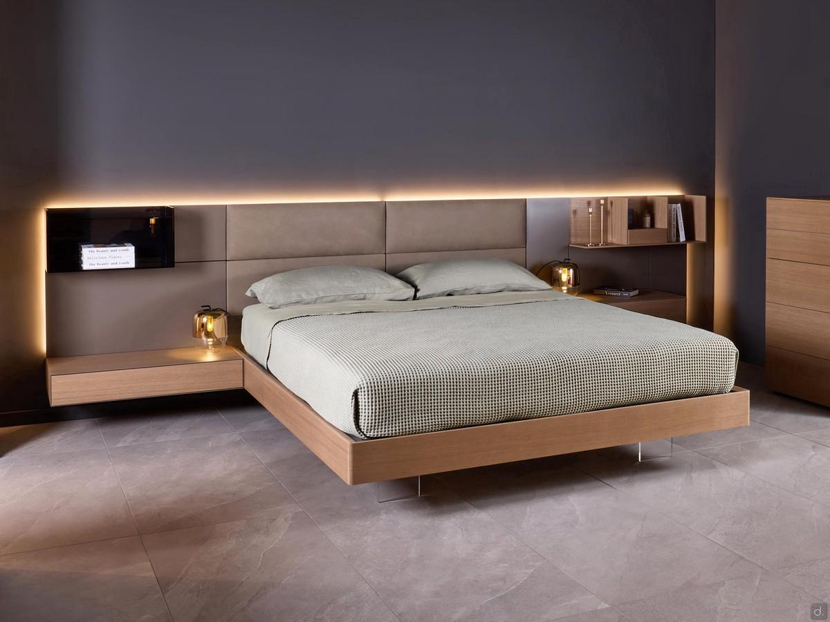 Letto in legno con boiserie California, qui proposto nella versione con testiera imbottita e boiserie laterale laccata opaca. Giroletto e comodini in rovere Avana