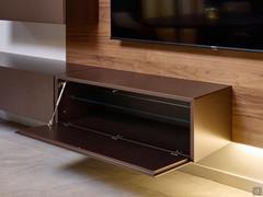 Base sospesa a ribalta Freehand in laccato metal bronzo, con alle spalle una boiserie in noce canaletto