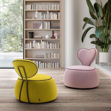 Poltroncina senza braccioli per cameretta Alice con base a pouf e schienale ovale o a cuore. Disponibile in tessuto, similpelle o velluto