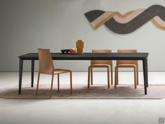 Sedie Corinne tutte rivestite in cuoio naturale, abbinate al tavolo da pranzo Redmoon in legno impiallacciato rovere fashion wood