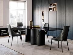 Elegante sala da pranzo con sedie Lora e tavolo Torquay in total black: seduta in pelle nera trapuntata a righe verticali e gambe in frassino tinto nero