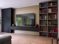 Parete attrezzata con spazio per televisione, armadio contenitore, libreria con scaffali.