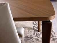 Particolare del piano in legno essenza del tavolo Nelia, con profilo bordato e angoli arrotondati ad assecondare la sagomatura delle gambe in legno