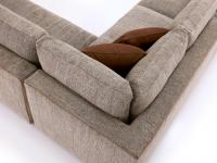 Detail of the corner element of the Clive sofa, with 90° backrest with contrasting edging and upholstered cushions
