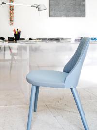 Particolare della sedia Neva con gambe e rivestimento sui toni dell'azzurro (versione con retro-schienale in legno non disponibile; lo schienale è interamente rivestito anche posteriormente)
