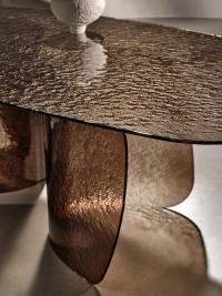 Lens hammered glass shaped table with curved base that reveals special plays of light